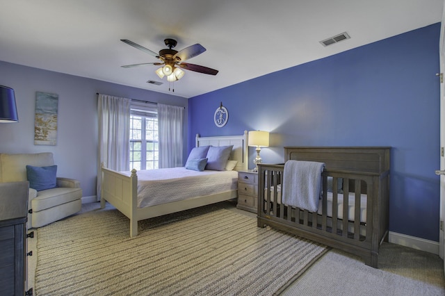 carpeted bedroom featuring baseboards, visible vents, and ceiling fan