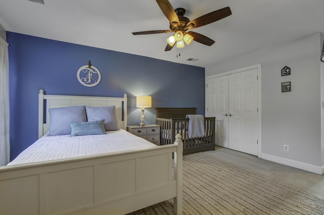 bedroom with baseboards, visible vents, a ceiling fan, light colored carpet, and a closet