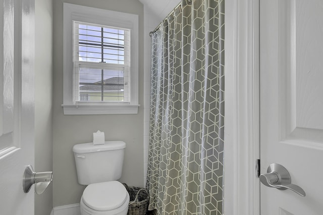 bathroom with a shower with shower curtain and toilet