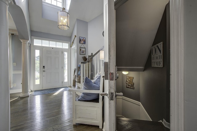 entrance foyer featuring stairs, dark wood-type flooring, and decorative columns