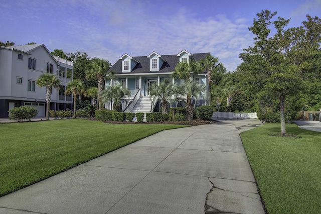 coastal inspired home with a porch, stairway, and a front lawn