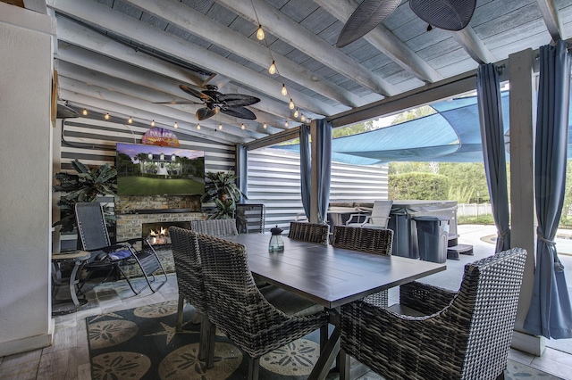 view of patio / terrace with a hot tub, outdoor dining area, and a ceiling fan