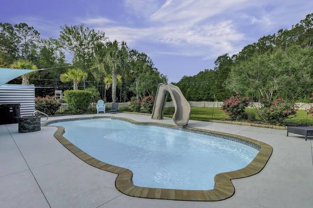 view of pool featuring a fenced in pool, fence, a water slide, and a patio