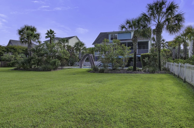 view of yard with a sunroom and fence