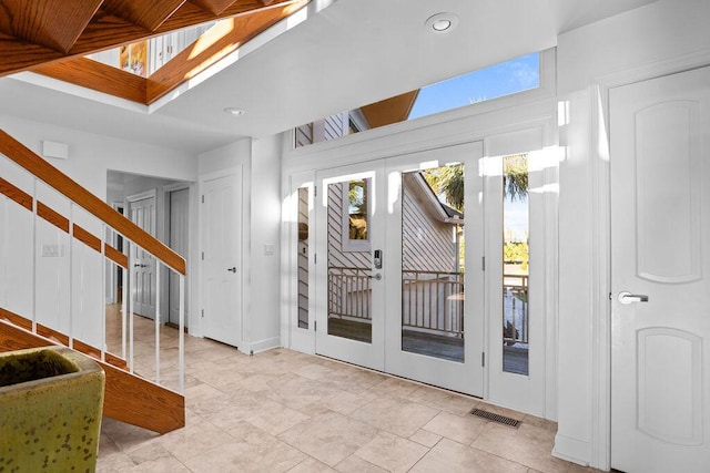 entrance foyer with a skylight, french doors, recessed lighting, visible vents, and stairs