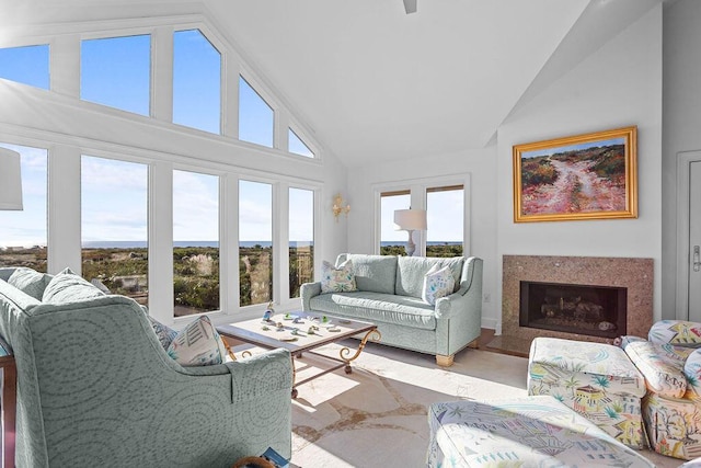 living room featuring high vaulted ceiling and a premium fireplace