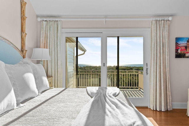 bedroom with access to outside, baseboards, and wood finished floors