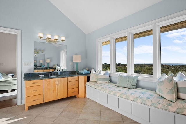 ensuite bathroom with ensuite bath, high vaulted ceiling, tile patterned flooring, and vanity