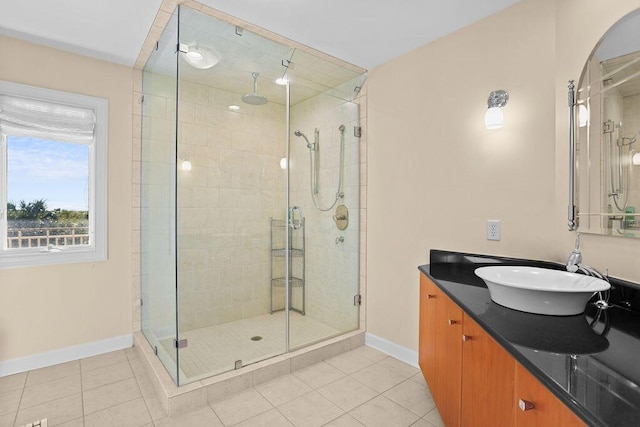 bathroom with a stall shower, tile patterned flooring, vanity, and baseboards