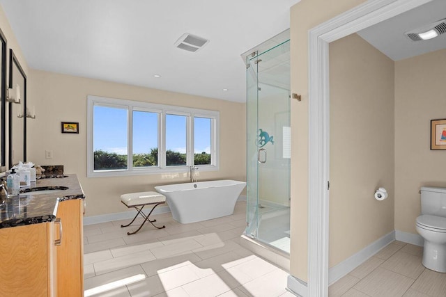 full bath with a stall shower, visible vents, toilet, vanity, and a freestanding tub