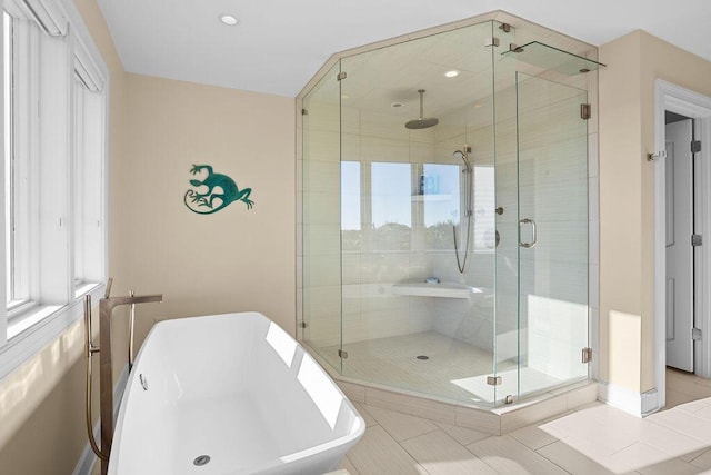 bathroom with a freestanding bath, a shower stall, and tile patterned floors