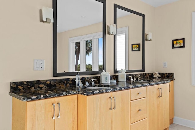 full bathroom featuring double vanity, a sink, and baseboards