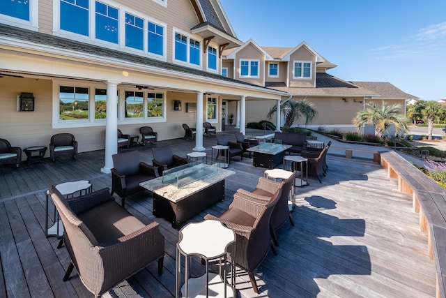 wooden deck featuring an outdoor living space with a fire pit