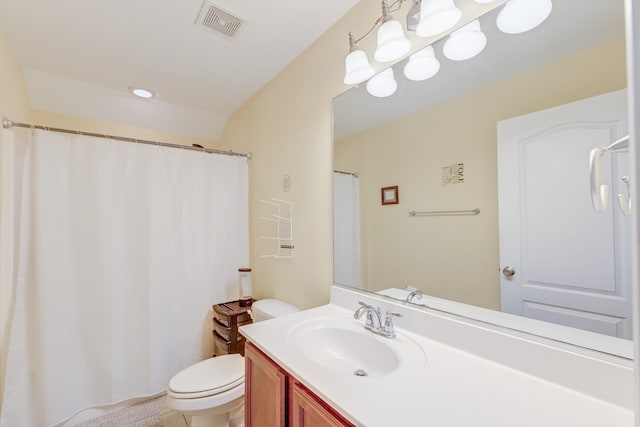 bathroom with curtained shower, vanity, and toilet