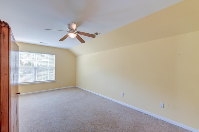 carpeted spare room with vaulted ceiling and ceiling fan