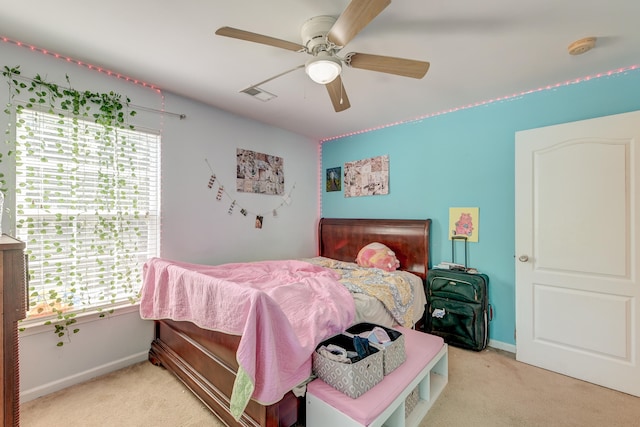 carpeted bedroom featuring multiple windows and ceiling fan