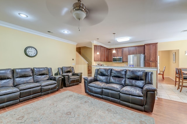 living room featuring light hardwood / wood-style floors, ornamental molding, and ceiling fan