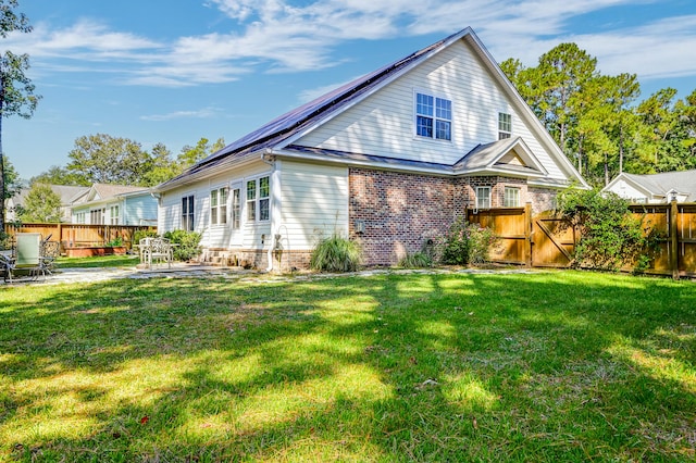 rear view of house with a lawn and a patio area