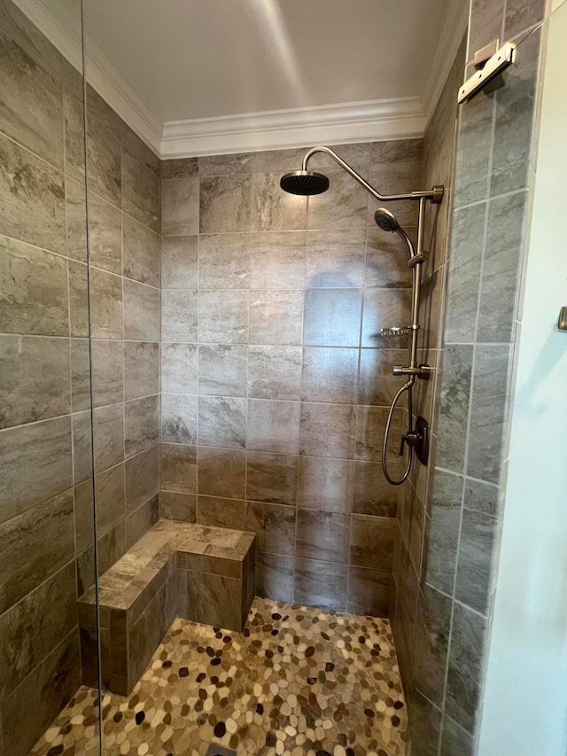 bathroom featuring ornamental molding and tiled shower