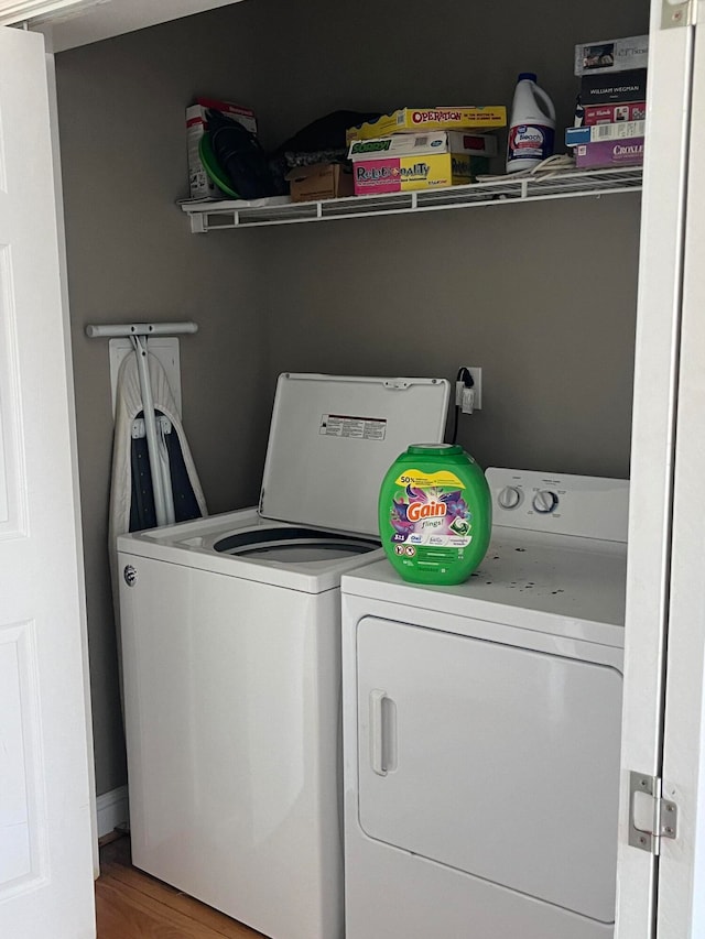 laundry room with independent washer and dryer and wood-type flooring