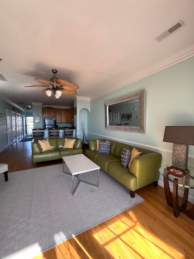 living room with ornamental molding, hardwood / wood-style flooring, and ceiling fan