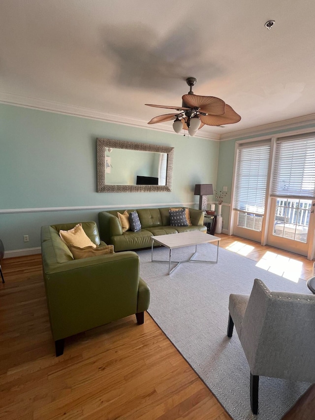 living room with crown molding, wood-type flooring, and ceiling fan