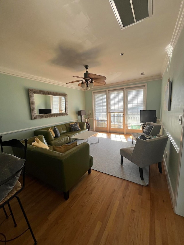 living room featuring hardwood / wood-style floors, crown molding, and ceiling fan