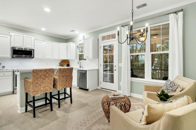 kitchen featuring white cabinets, appliances with stainless steel finishes, pendant lighting, and sink