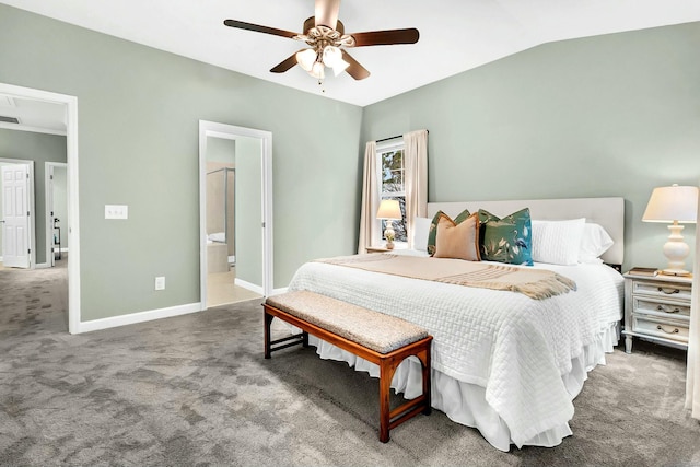 bedroom with carpet flooring, vaulted ceiling, ensuite bath, and ceiling fan