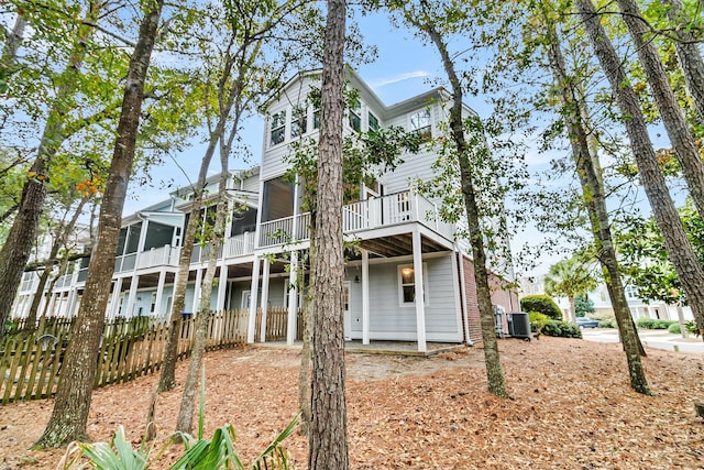 back of house with central AC unit and a sunroom