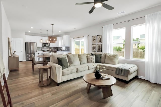 living room with ceiling fan, light wood-style flooring, recessed lighting, and baseboards