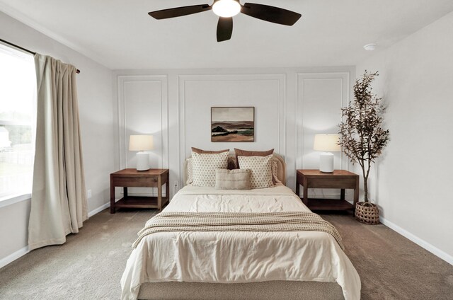 carpeted bedroom with ceiling fan and baseboards