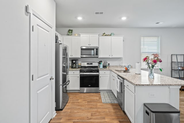 1014 Peridote Way, Ladson, SC 29456 - kitchen featuring appliances with stainless steel finishes, a peninsula, light wood-type flooring, white cabinets, and a sink