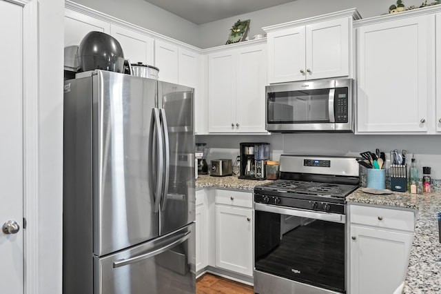 1014 Peridote Way, Ladson, SC 29456 - kitchen with stainless steel appliances, white cabinetry, and light stone counters
