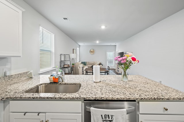 1014 Peridote Way, Ladson, SC 29456 - kitchen with stainless steel dishwasher, a sink, open floor plan, white cabinetry, and light stone counters