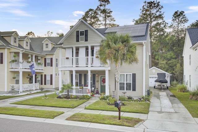 view of front of house with a garage, solar panels, an outdoor structure, covered porch, and a front lawn