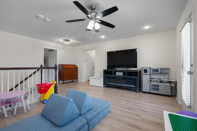 living room with light wood-style flooring, a ceiling fan, recessed lighting, and baseboards