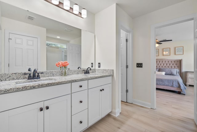 full bathroom with a sink, visible vents, baseboards, and wood finished floors