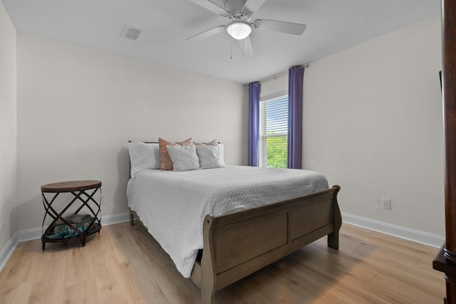 bedroom with visible vents, baseboards, a ceiling fan, and wood finished floors