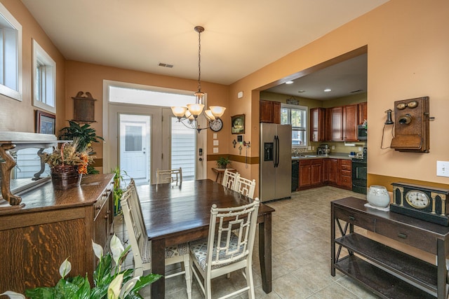 dining space featuring sink and an inviting chandelier