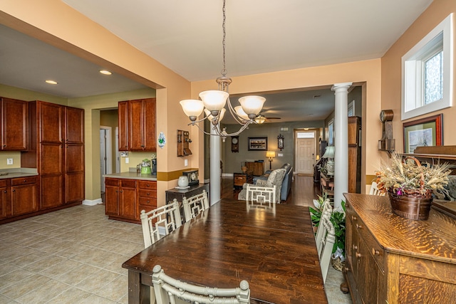 dining room featuring an inviting chandelier and ornate columns