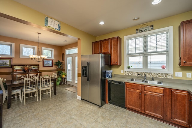 kitchen featuring pendant lighting, dishwasher, sink, a notable chandelier, and stainless steel fridge with ice dispenser