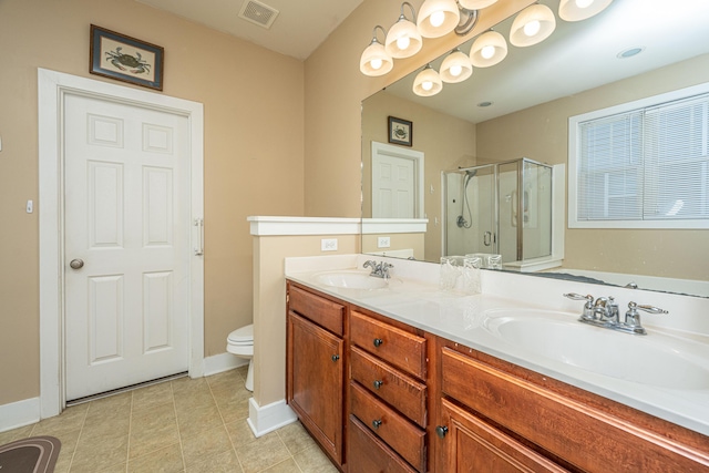 bathroom with tile patterned floors, vanity, toilet, and a shower with shower door