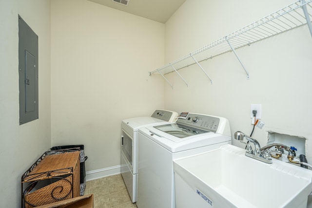 laundry room featuring washing machine and dryer, sink, and electric panel