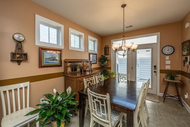 dining space featuring a wealth of natural light and an inviting chandelier