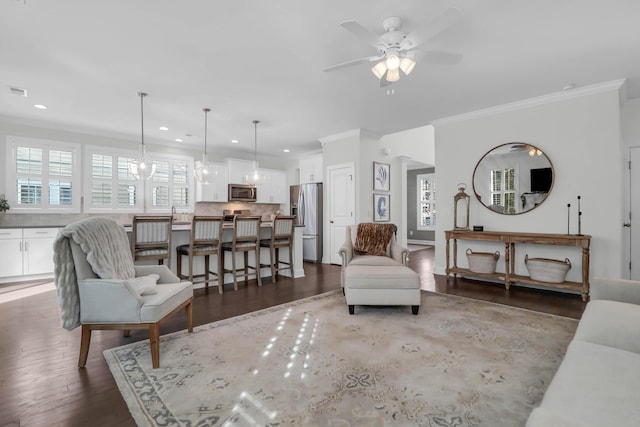 living room featuring dark hardwood / wood-style flooring, ceiling fan, and crown molding