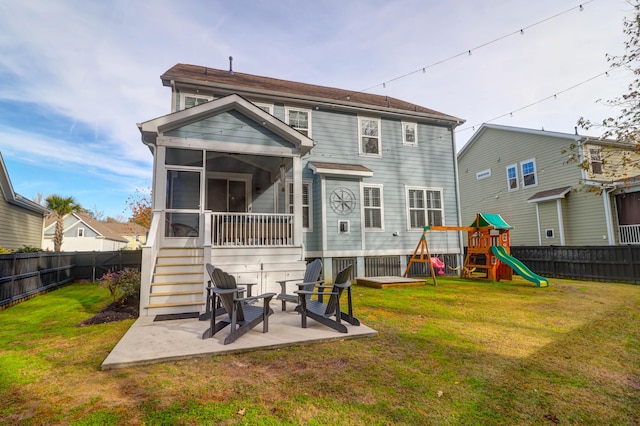 back of house with a lawn, a patio area, a sunroom, and a playground