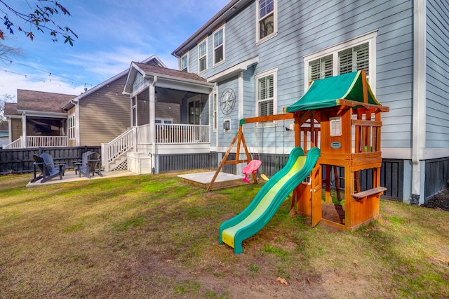 view of play area featuring a patio area, a sunroom, and a yard