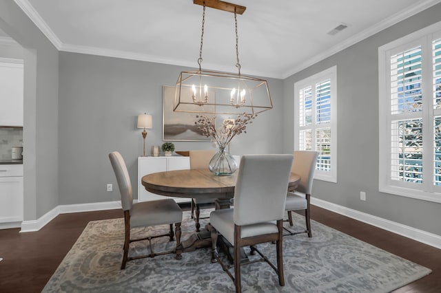 dining area with dark hardwood / wood-style floors, ornamental molding, and a chandelier