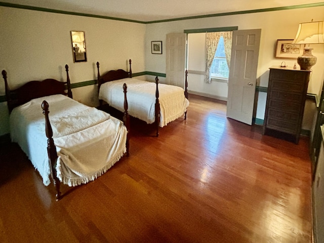 bedroom with wood-type flooring and crown molding